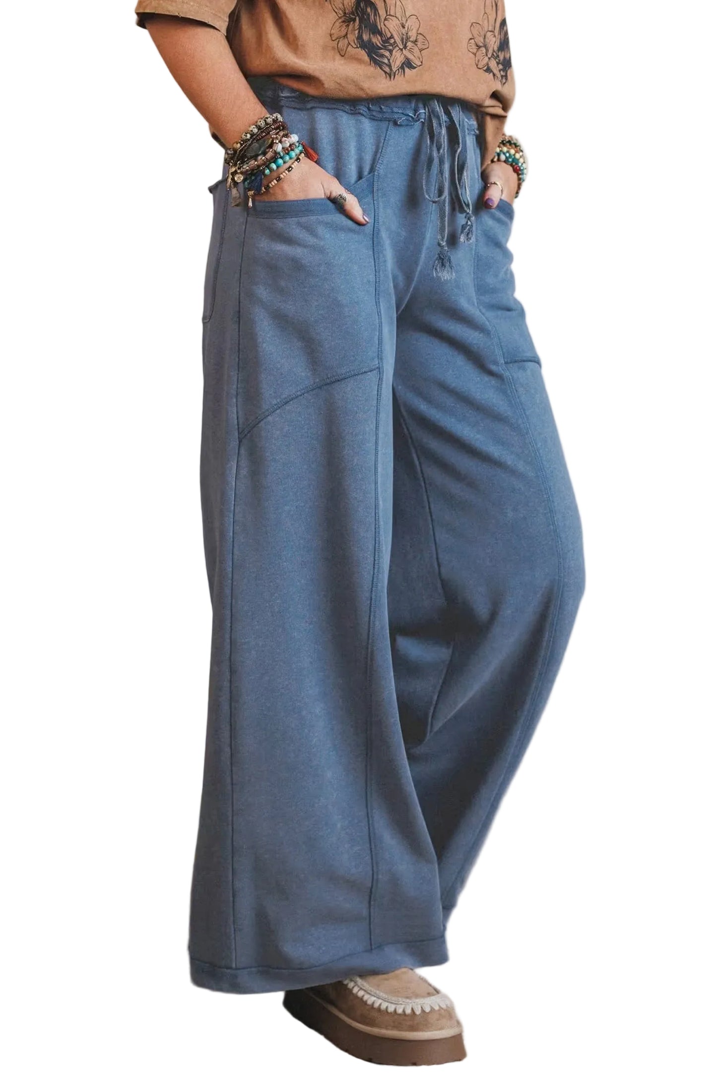 Person wearing blue wide-leg pants with a neutral background