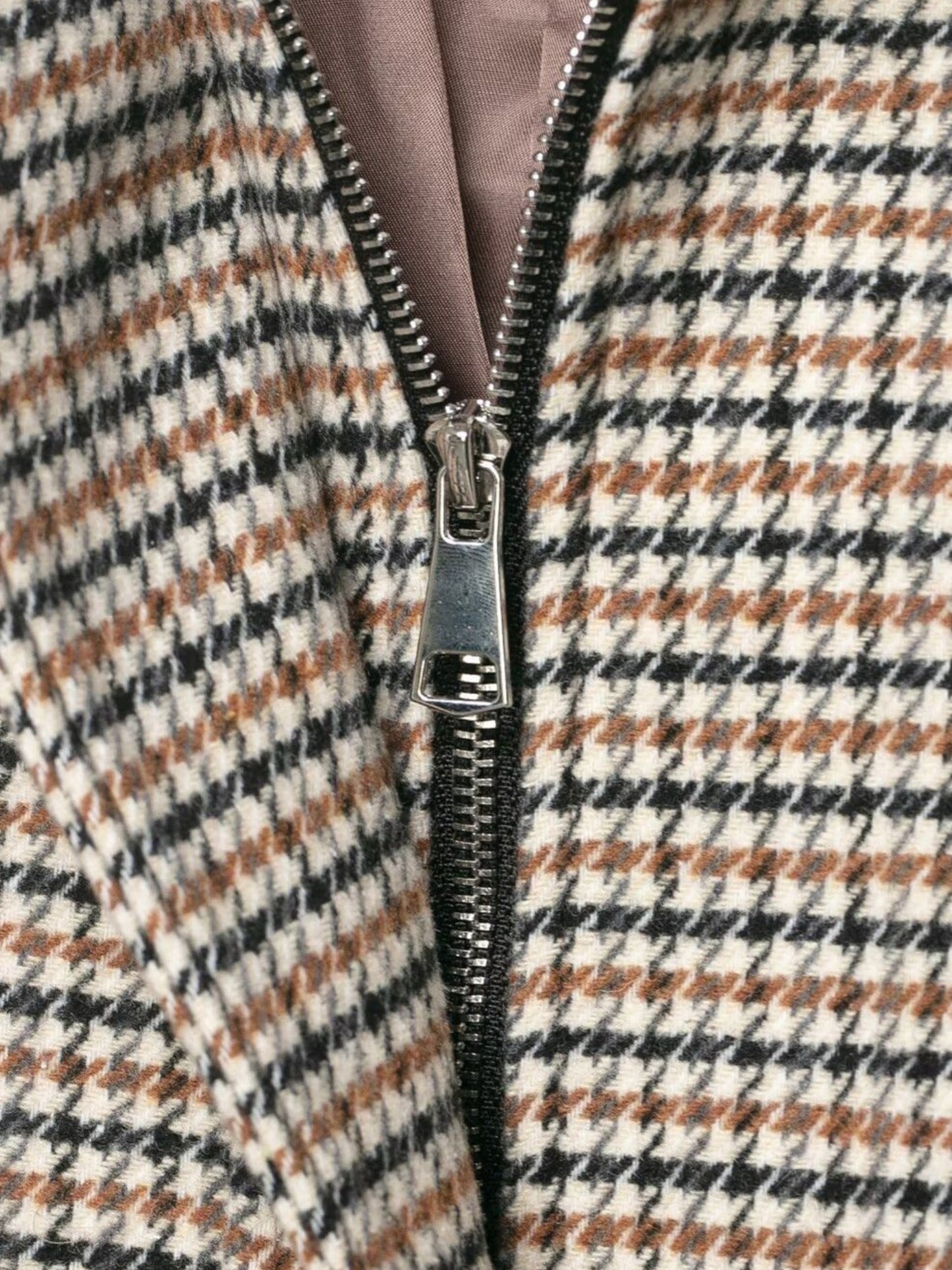Close-up of a houndstooth coat with a zipper front