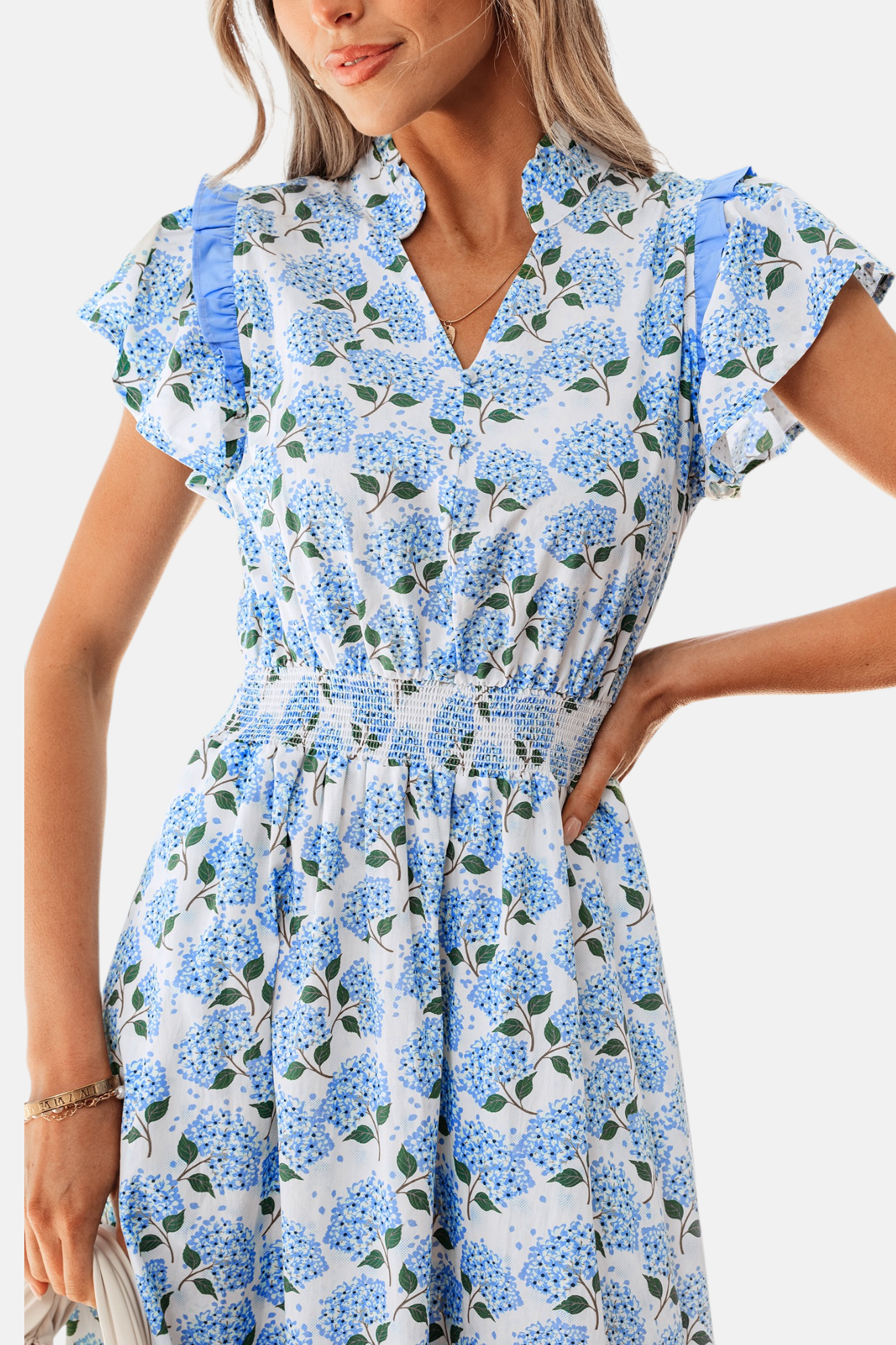 Close-up of the bodice on a floral midi dress highlighting the delicate V-neckline, smocked waist detailing, and ruffle shoulder accents.