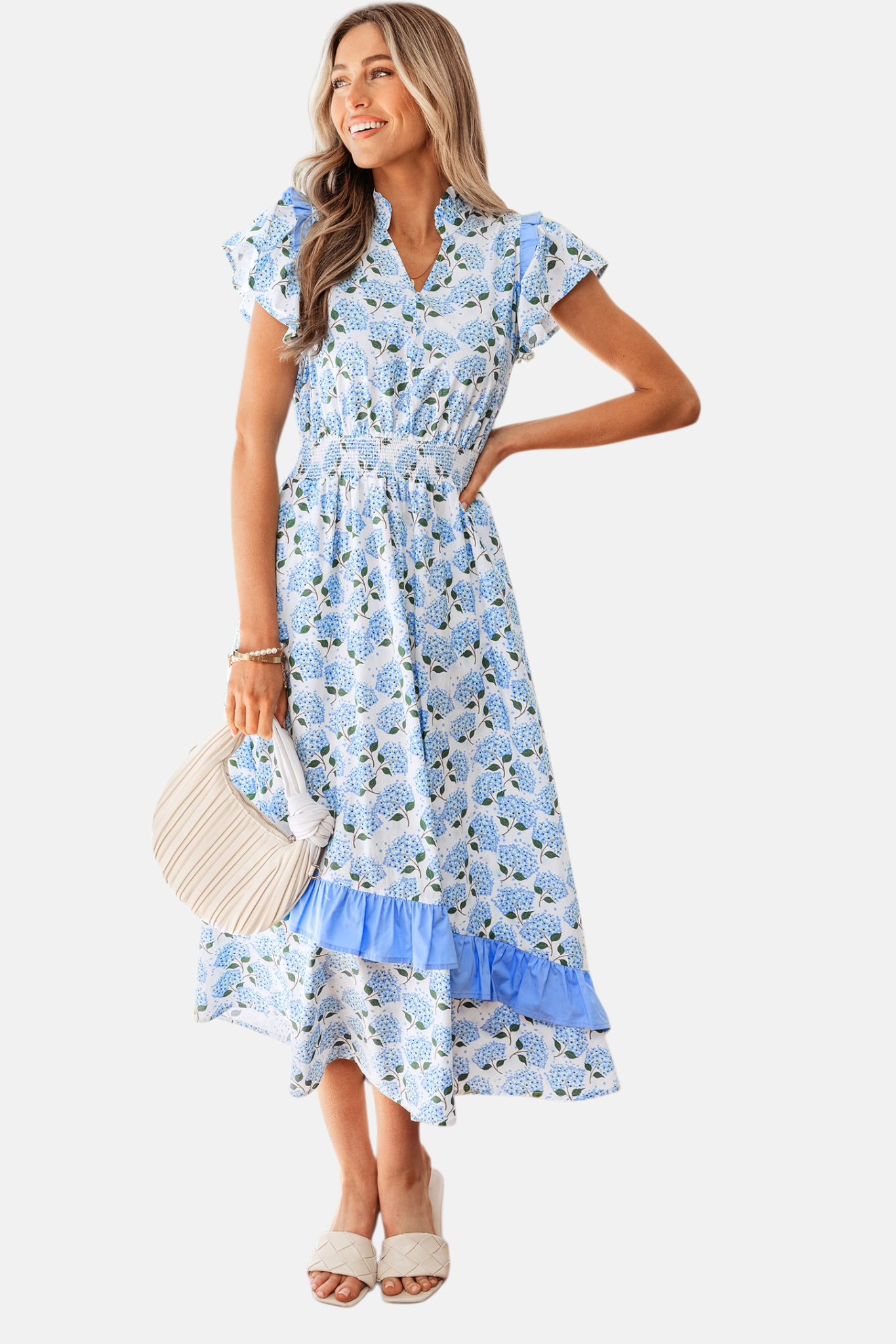 Full-length studio shot of a model in a hydrangea-print midi dress showing the flowy asymmetric hem and flattering smocked silhouette.
