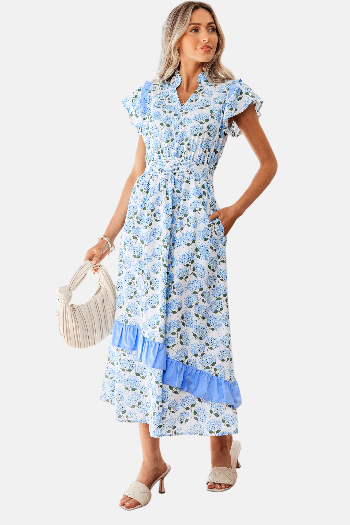 A lifestyle pose of the hydrangea floral midi dress showcasing the movement of the ruffled skirt and the vibrant sky-blue floral pattern.