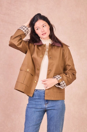 Front view of a model wearing a khaki 100% cotton field jacket with a burgundy corduroy collar and checkered turned-up cuffs.