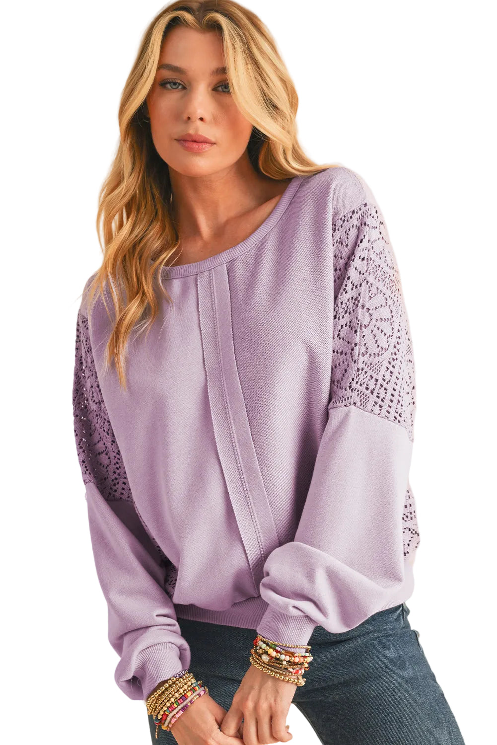 Woman wearing a light purple blouse with lace sleeves on a white background