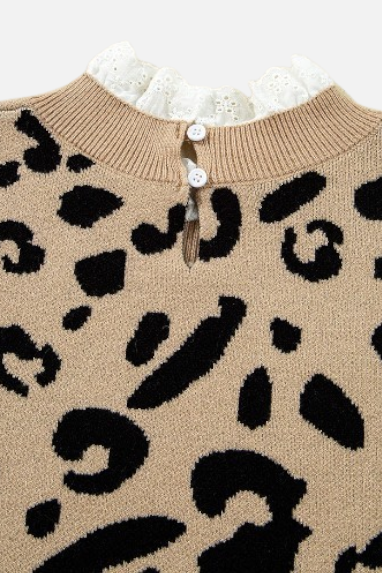 Close-up of the back neckline on a leopard print sweater, highlighting the delicate white lace trim and functional double button keyhole closure.