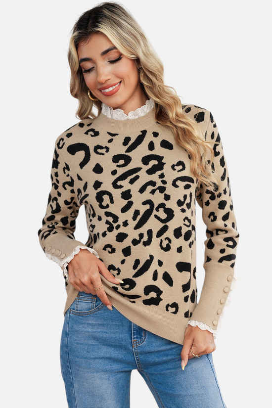 Model wearing the leopard print knit sweater paired with blue jeans, showcasing the elongated ribbed cuffs with decorative tonal buttons.