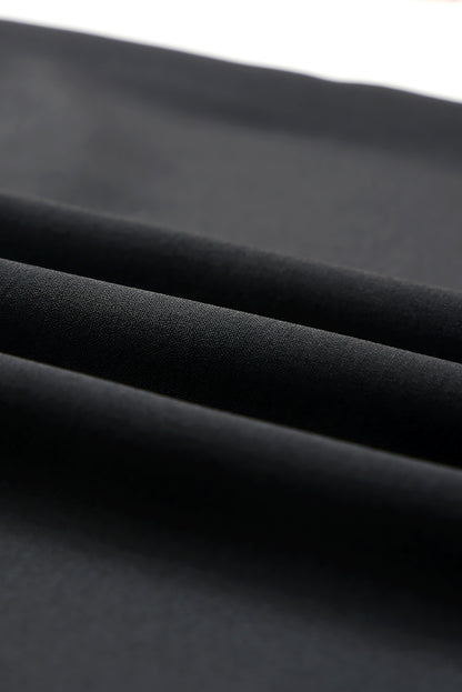 Fabric view of a ladies' black dress with soft ruffle sleeve details.