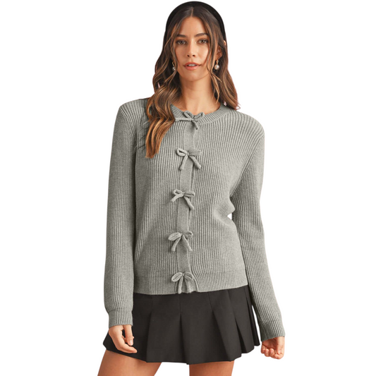 Woman wearing a gray ribbed sweater with bow details on a white background