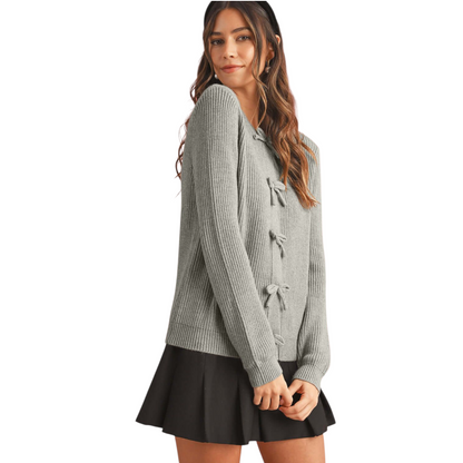 Woman wearing a gray cardigan with button details on a white background