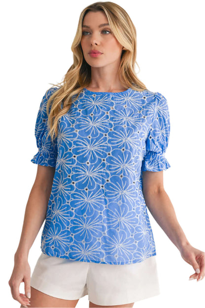 Romantic boho-style blouse in sky blue with floral patterns and eyelet details.