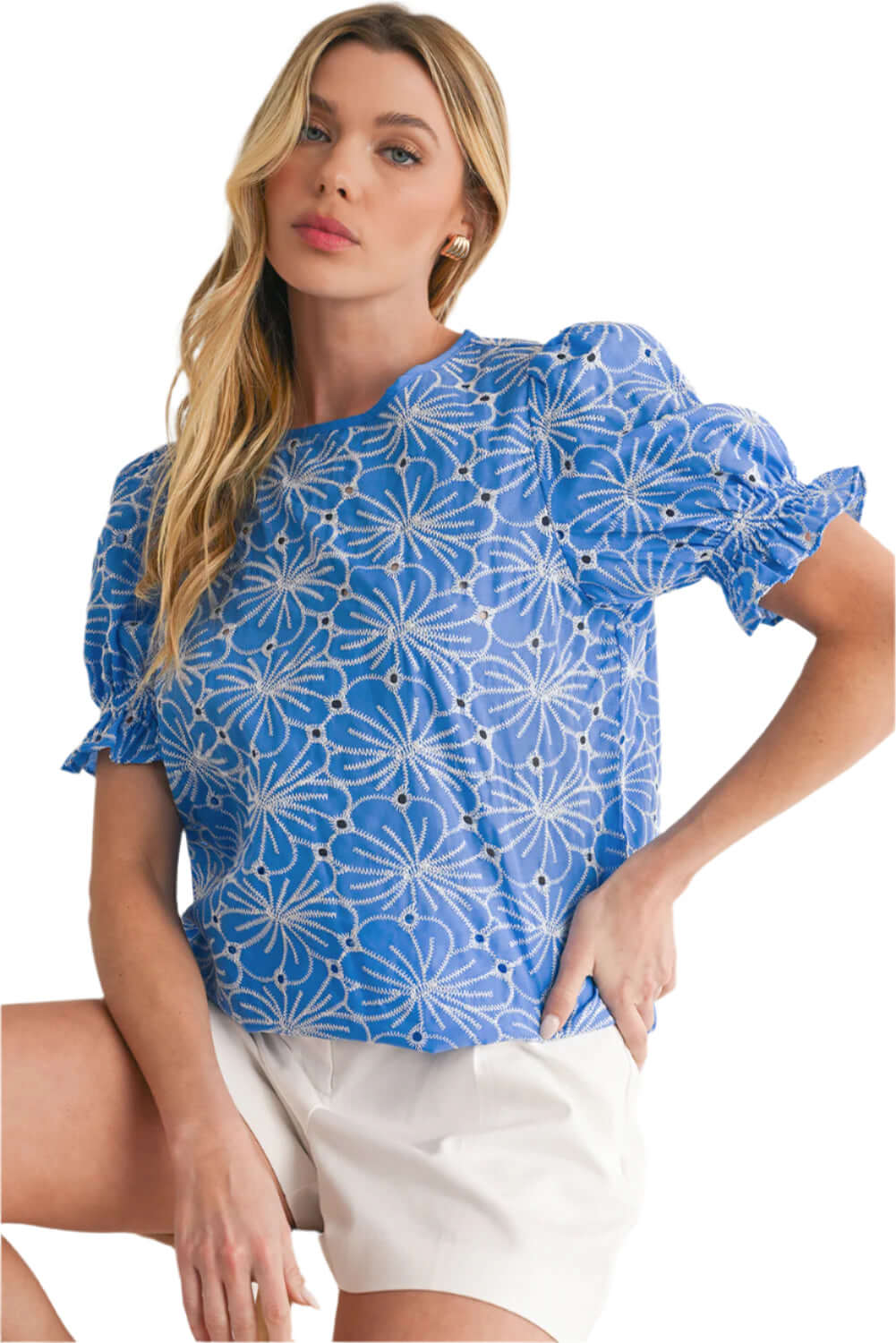 Model wearing a sky blue floral blouse with intricate eyelet accents and frill details.