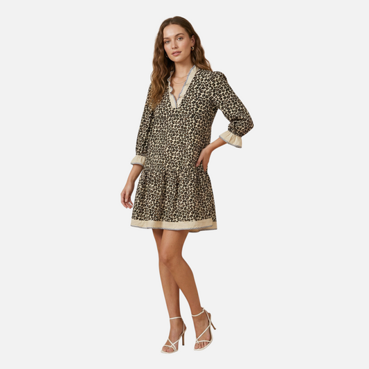 A model wearing a leopard print tiered mini dress with bracelet-length sleeves and elegant V-neck styling.