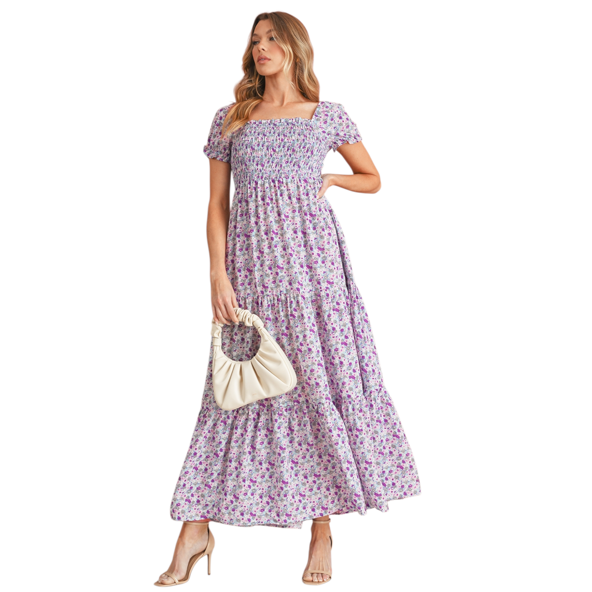 Model wearing a lilac and purple floral smocked maxi dress with short puff sleeves and a tiered skirt. The dress features a square neckline and an elasticated smocked bodice for a flattering fit.