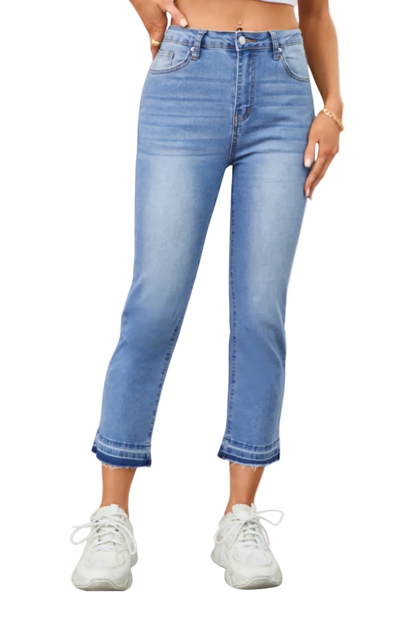 Person wearing light blue jeans and white sneakers on a plain background