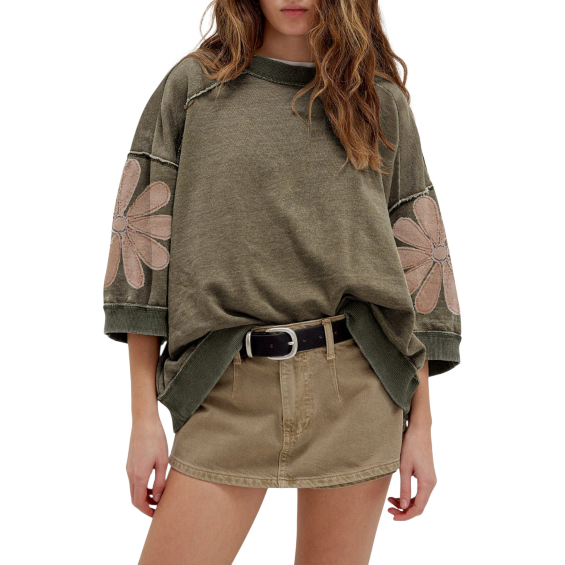 Close-up of a deconstructed sweatshirt in a mineral wash olive hue, highlighting the raw-edge diagonal seams and large mauve floral appliqués on the sleeves.