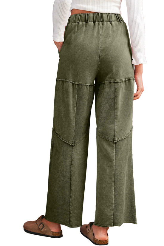 Back view of a green wide-leg pants worn by a person on a white background