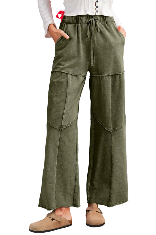 Green casual pants worn by a person on a white background