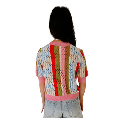 Person wearing a colorful striped sweater on a white background
