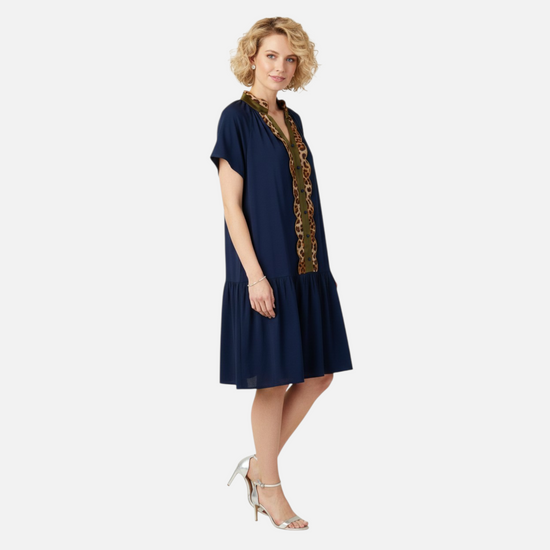 Front view of a navy shift dress featuring leopard print patchwork, olive contrast trim, and button details on a soft viscose fabric.