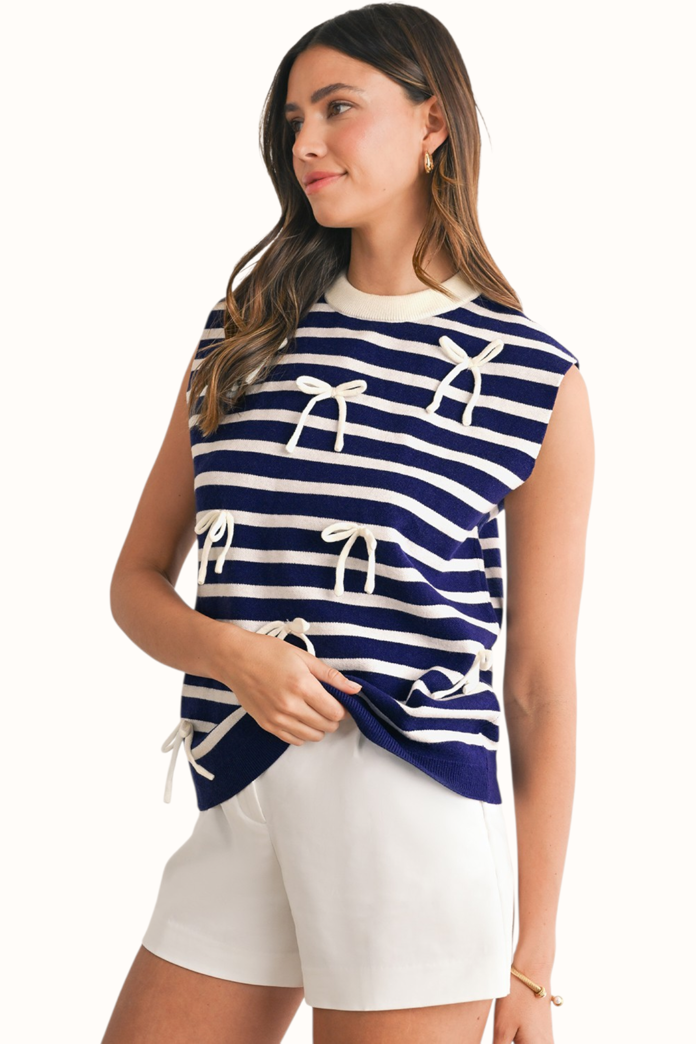 Front view of a navy and white horizontal striped knit vest featuring three delicate white decorative bows and a classic crew neckline.