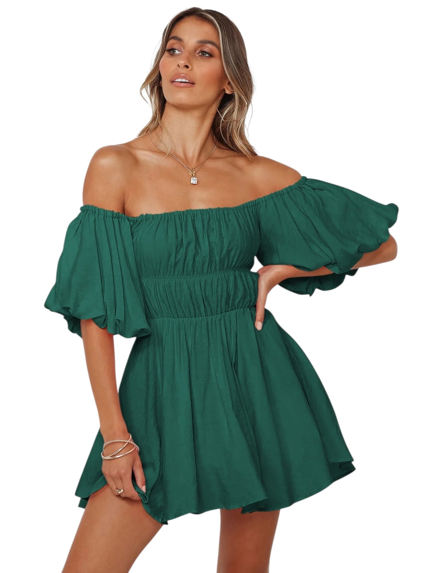 A woman modeling an off-the-shoulder green mini dress with voluminous puff sleeves and a gathered empire waist, shown against a plain white background.