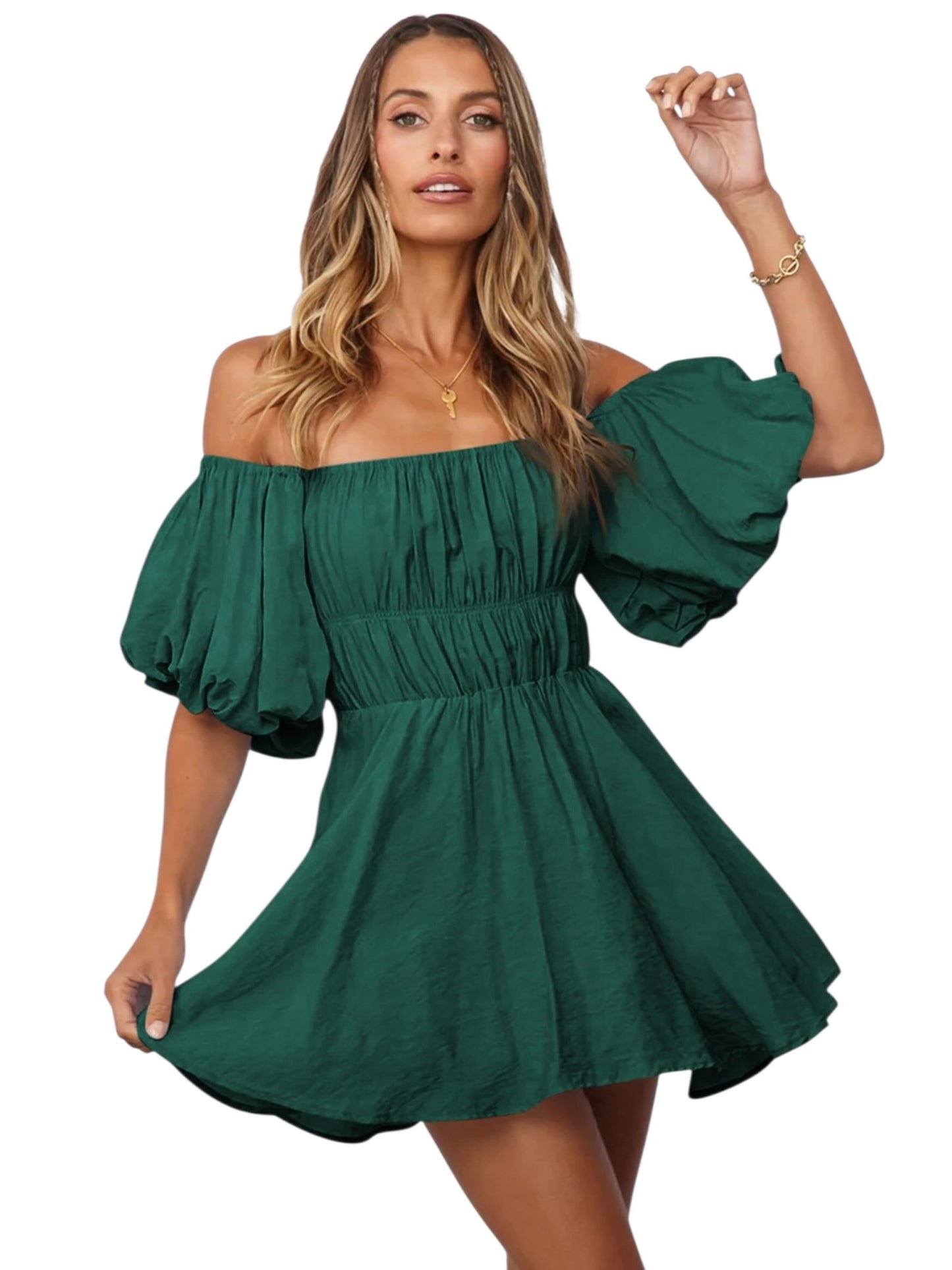 A woman modeling an off-the-shoulder mini dress in forest green. The dress features a gathered smocked bodice, a flared skirt, and voluminous puff sleeves.