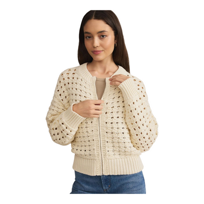 Woman wearing a beige zip-up sweater on a white background