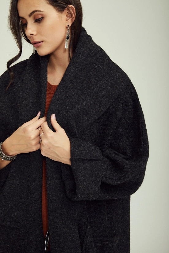 Woman wearing a dark gray coat against a plain background