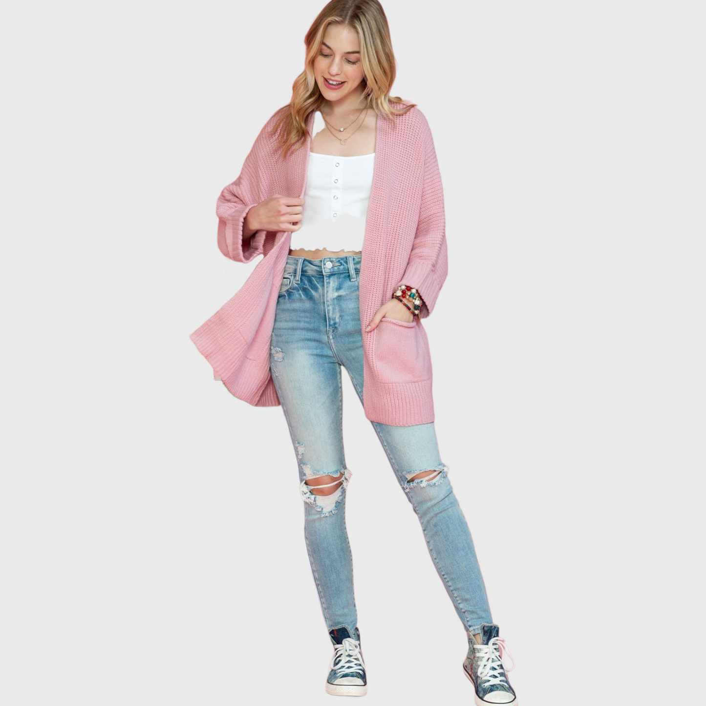 A full-length view of the dusty pink cardigan with an open front design, featuring ribbed fold-over cuffs and large front pockets.