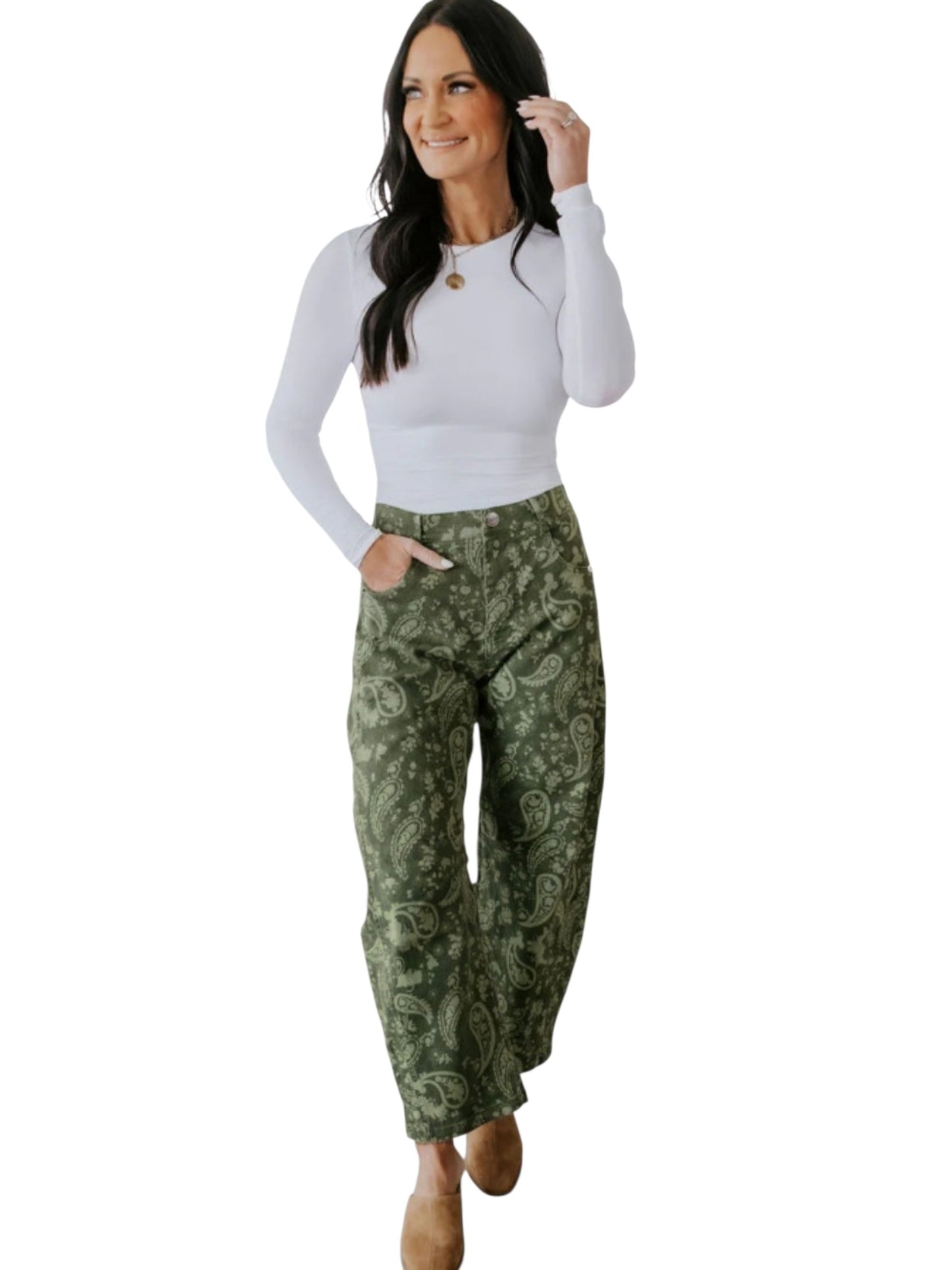 A woman modeling a white long-sleeve top and green paisley patterned pants against a plain white background.