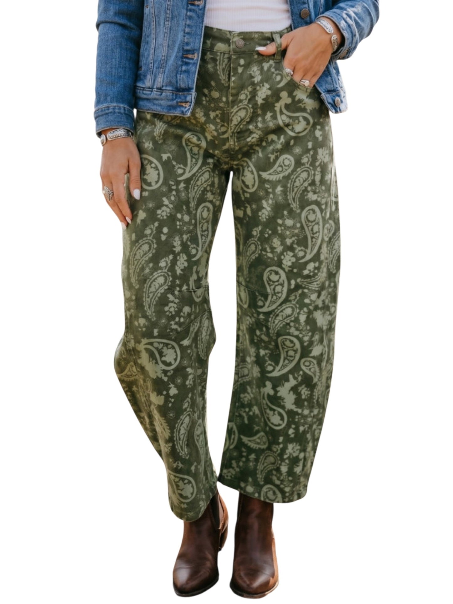 A person wearing wide-leg green pants with a beige paisley pattern, styled with a blue denim jacket, white top, and brown boots against a plain white background.
