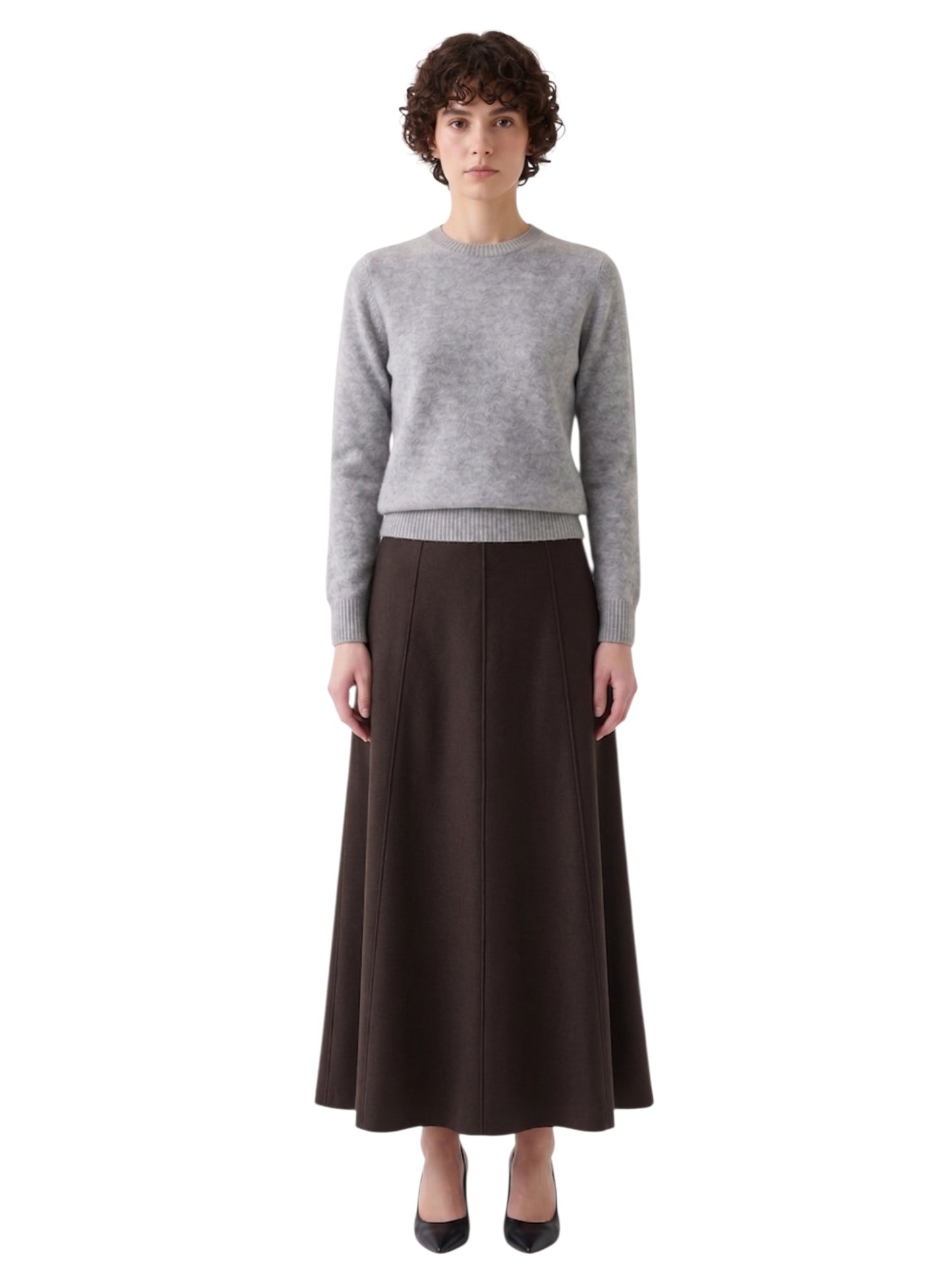 Full-length front shot of the model wearing the espresso brown stretch A-line long skirt with a fine-knit jumper.