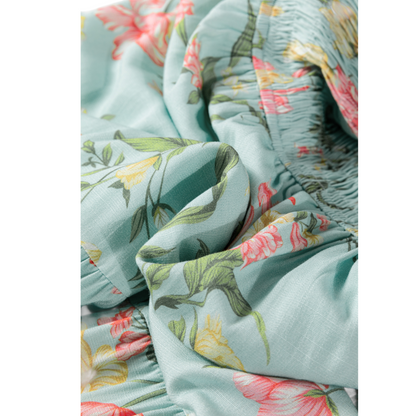 Close-up of floral fabric with pink and yellow flowers on a light blue background