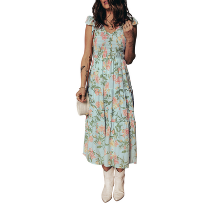 A tiered mint green maxi dress with a pastel floral print, featuring a smocked bodice and ruffled cap sleeves.
