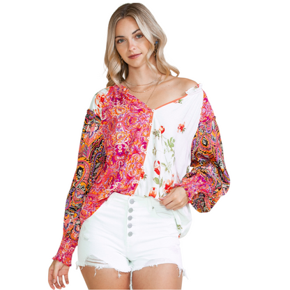 Woman wearing a multi-coloured patchwork floral viscose blouse with a V-neckline and button-down front.