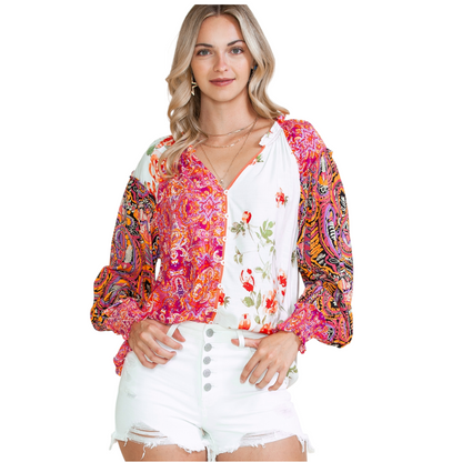 Woman wearing a multi-coloured patchwork floral viscose blouse with a V-neckline and button-down front.
