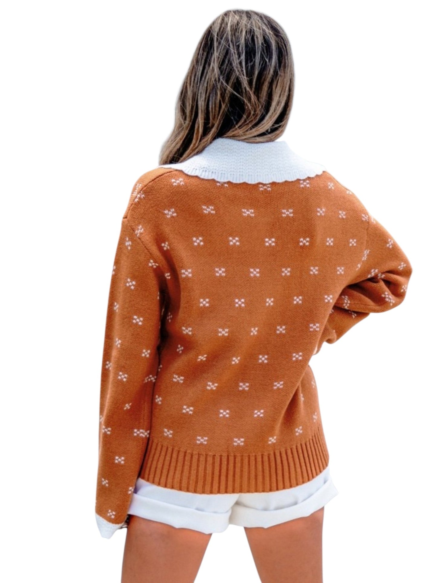 A woman shown from the back wearing a rust-orange knit sweater with a white patterned design and a white collar, paired with white shorts, against a plain white background.