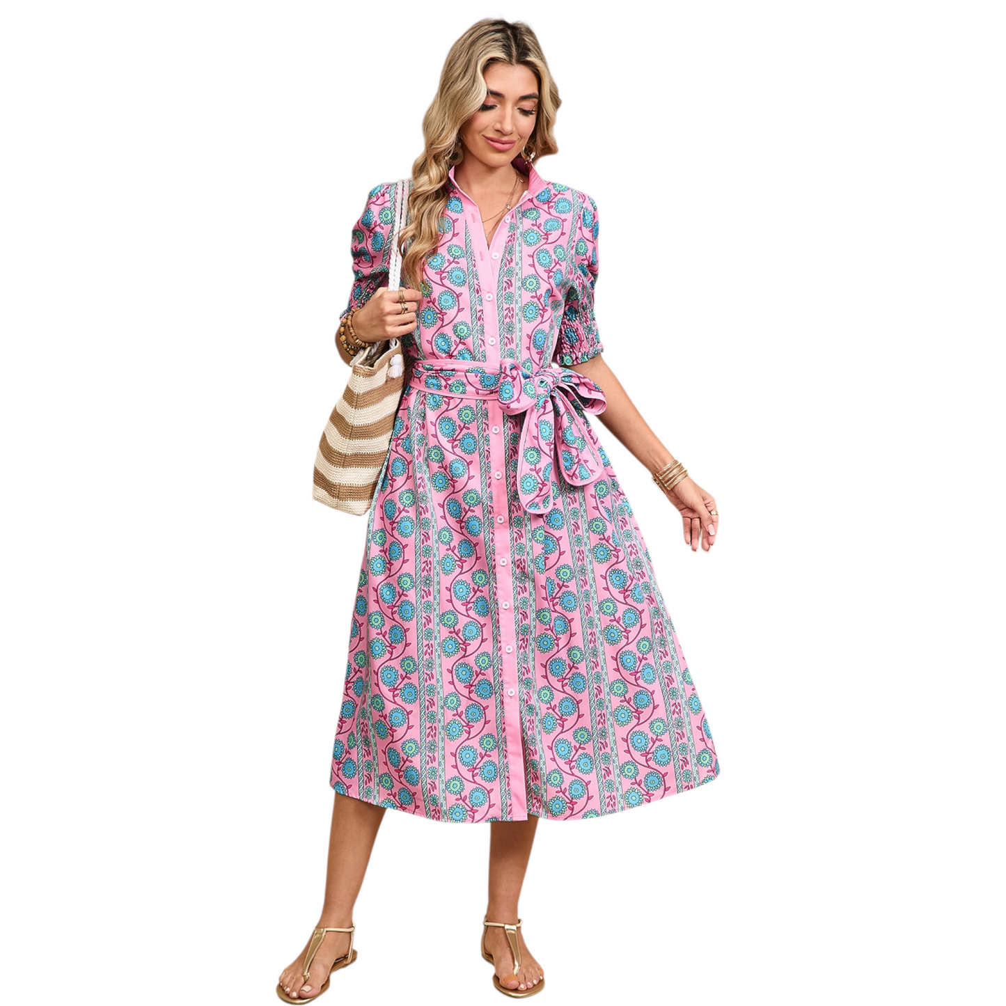 Woman wearing a pink button-down midi dress with a turquoise floral boho print and a matching waist tie belt.