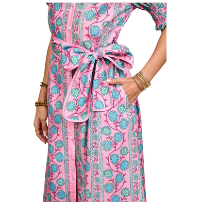 Close-up detail of the pink floral dress showing the matching self-tie waist belt and side pocket.