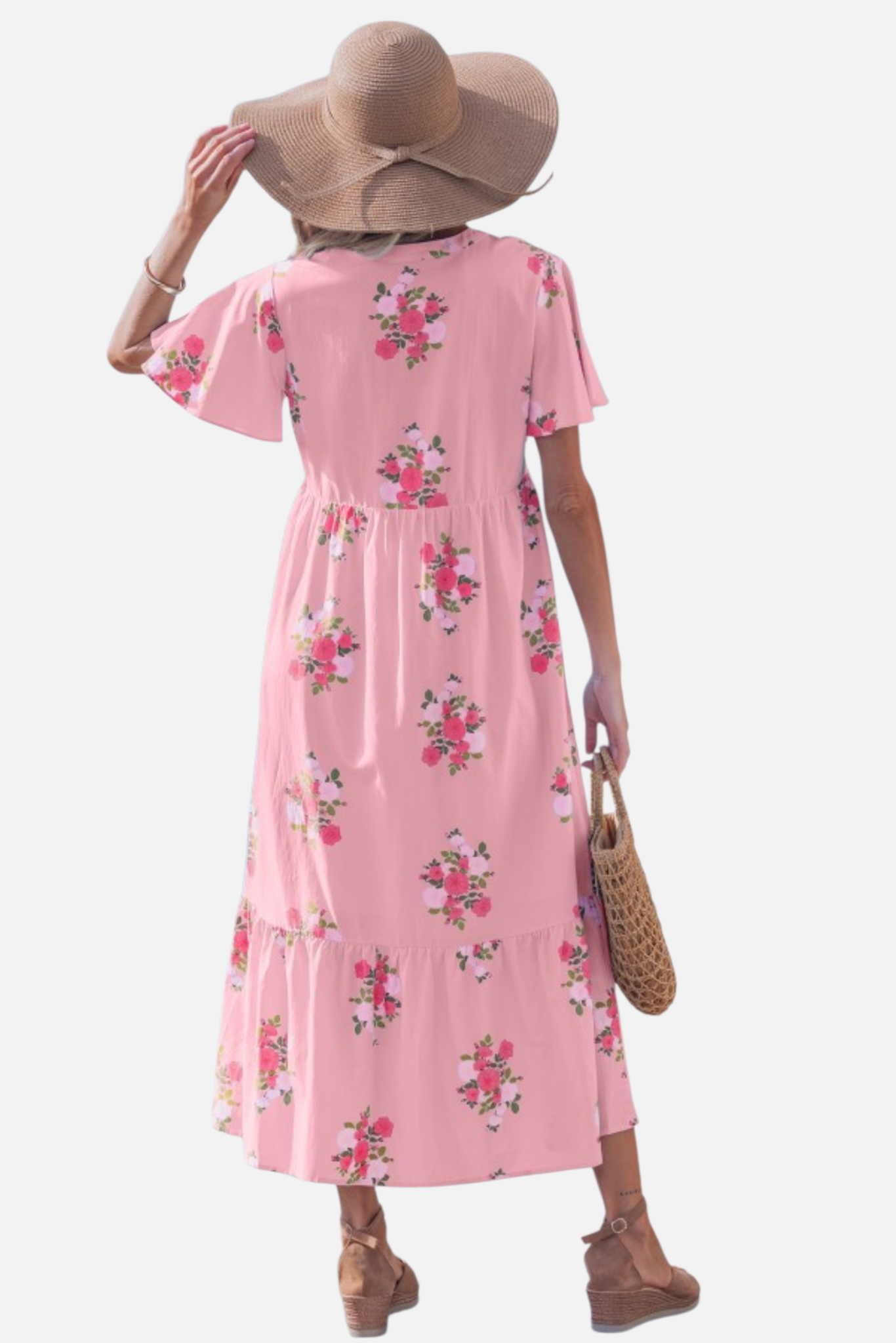 Rear view of a  woman wearing a light pink floral maxi dress with pink rose patterns, featuring flutter short sleeves, side pockets and a notched neckline.