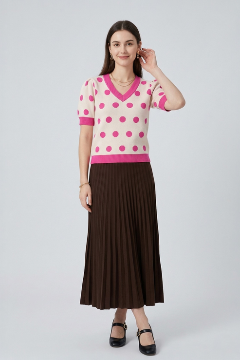 Full-length shot of a pink polka dot short-sleeve knit top styled with a brown midi skirt and black Mary Jane heels.