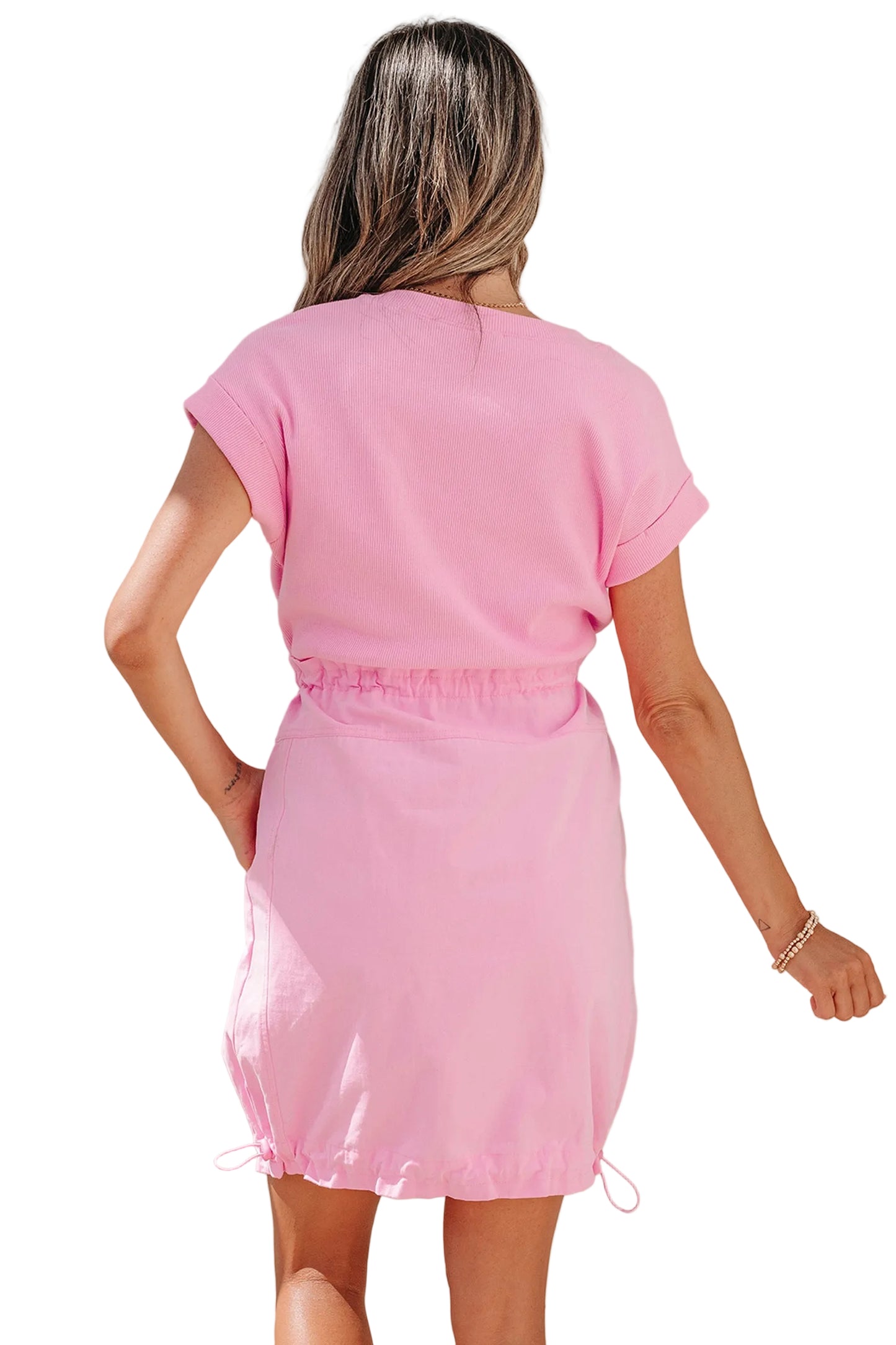 Woman wearing a pink dress against a plain background