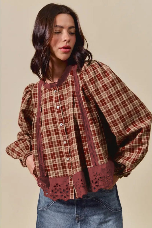 Woman wearing a plaid shirt with lace trim on a beige background