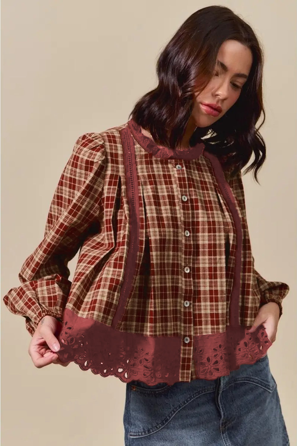 Woman wearing a plaid blouse with lace details on a beige background