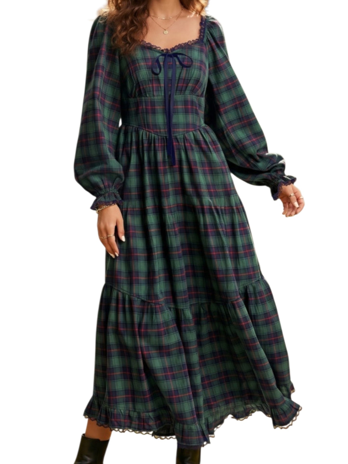A woman wearing a long-sleeve plaid midi dress in dark green, navy, and purple, featuring a square neckline with a tie, a gathered waist, and a tiered skirt.