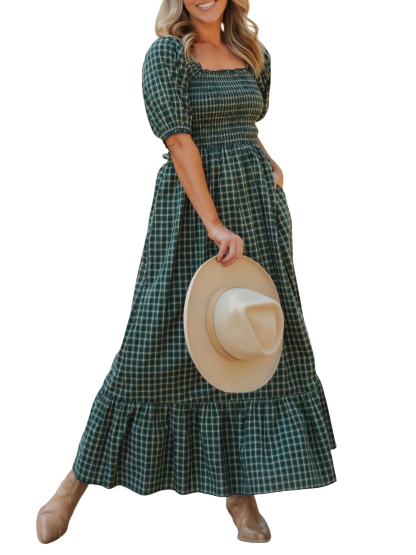 Woman wearing a green plaid dress holding a hat on a white background