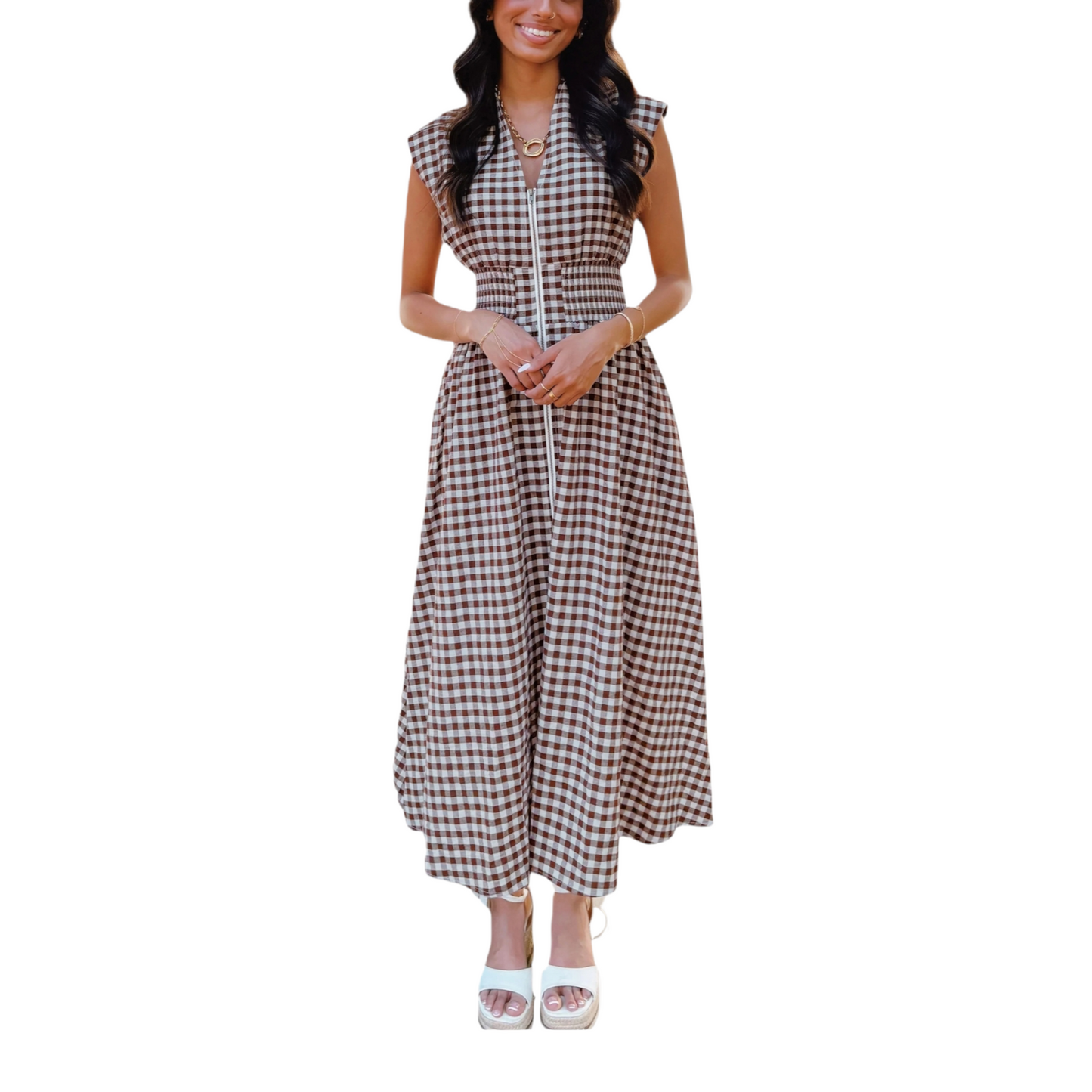 A woman wearing a sleeveless chocolate brown and white gingham maxi dress with a full-length front zipper and a wide smocked waistband.