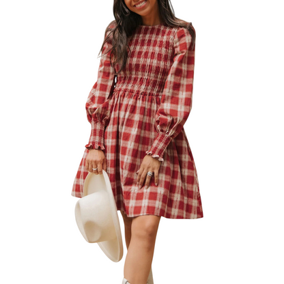 Woman wearing a red and white checkered dress holding a white hat on a white background