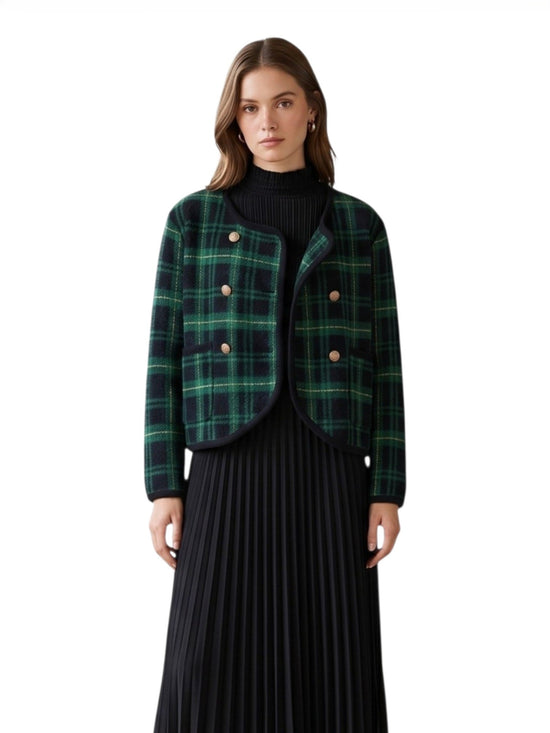 Woman wearing a green plaid jacket over a black outfit on a white background