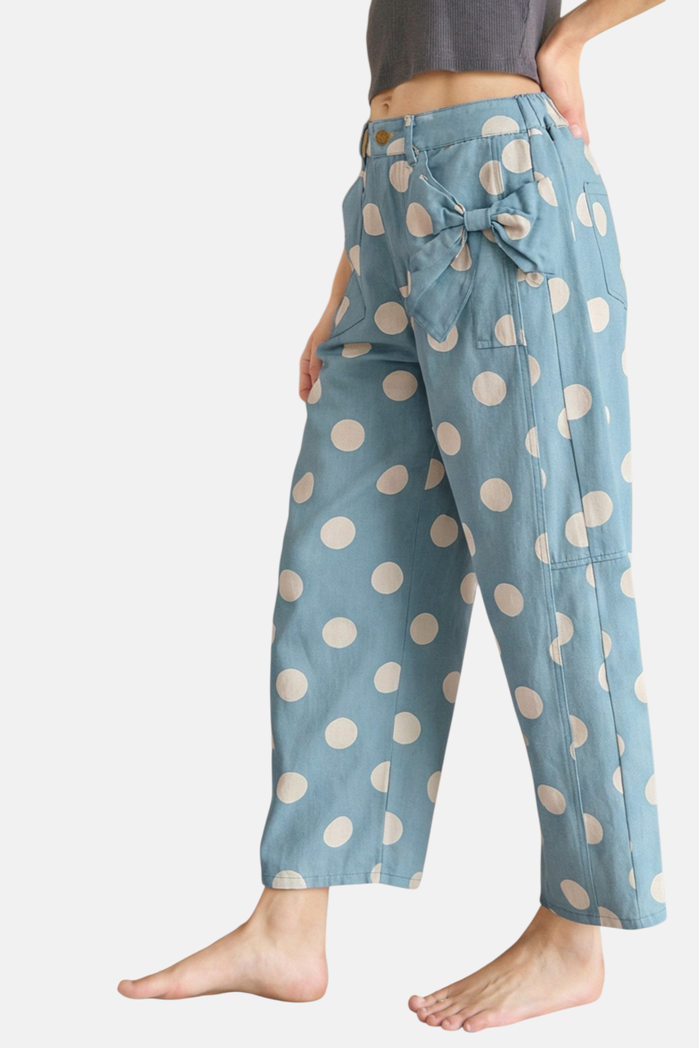 Light blue pants with white polka dots worn by a person on a white background