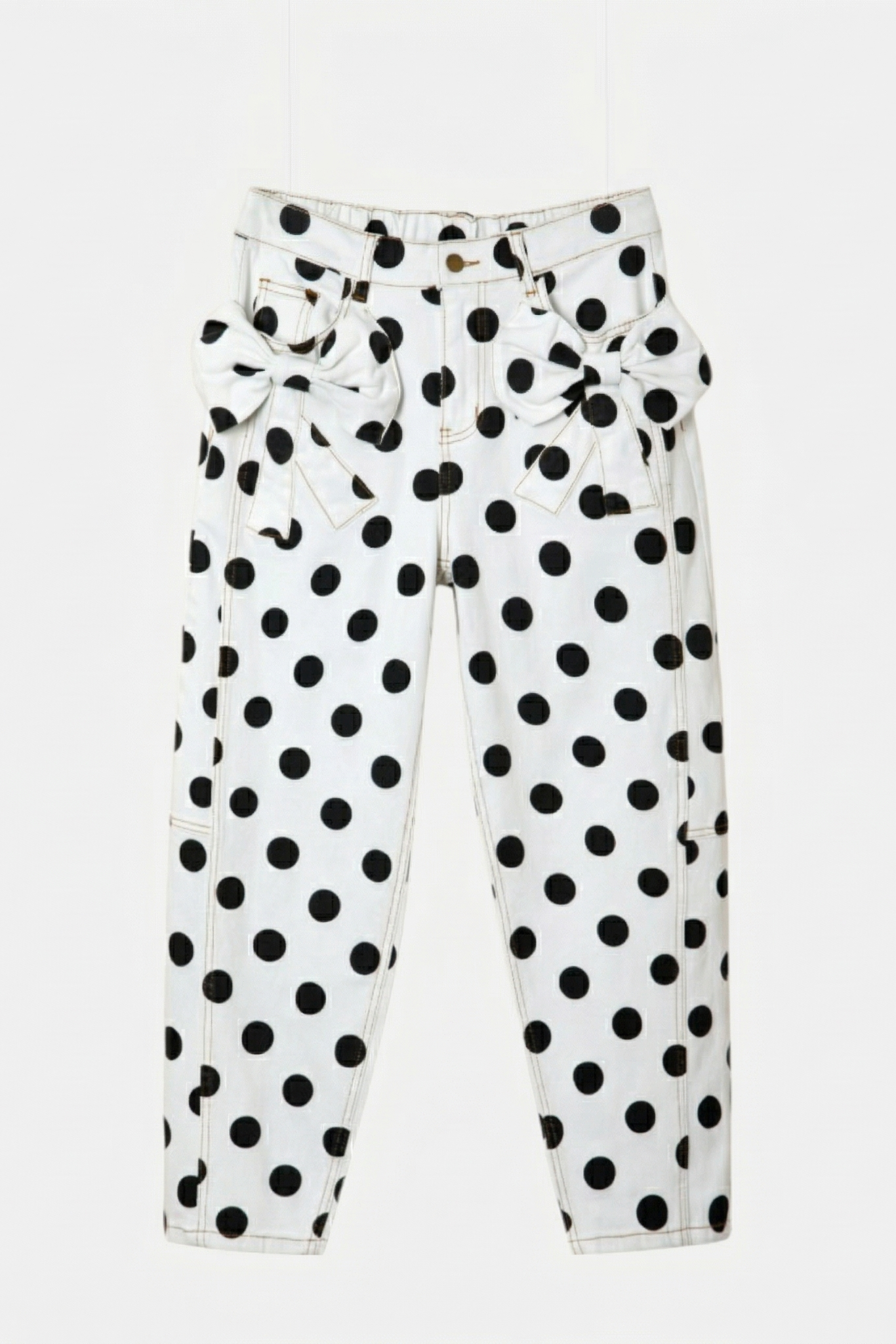 Professional front flat lay of white polka dot jeans with double denim bows and a high-waisted fit.